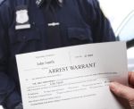 Arrest Warrant with man holding warrant next to police officer