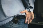 man takes a gun out of his pocket, the concept of self-defense or suppression, robbery. Legalization of firearms.