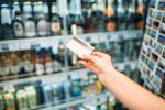 Female hand with credit card, alcohol market