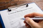 Person Filling Criminal Background Check Form