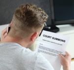 Man Reading Court Summons