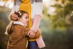 Sad girl feeling protected in her mother's embrace outdoors.