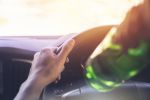 Man drinking alcohol while driving a car