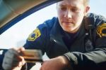 Male traffic officer checking a license