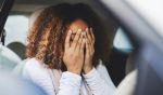 A young woman frustrated in her car because she cannot drive